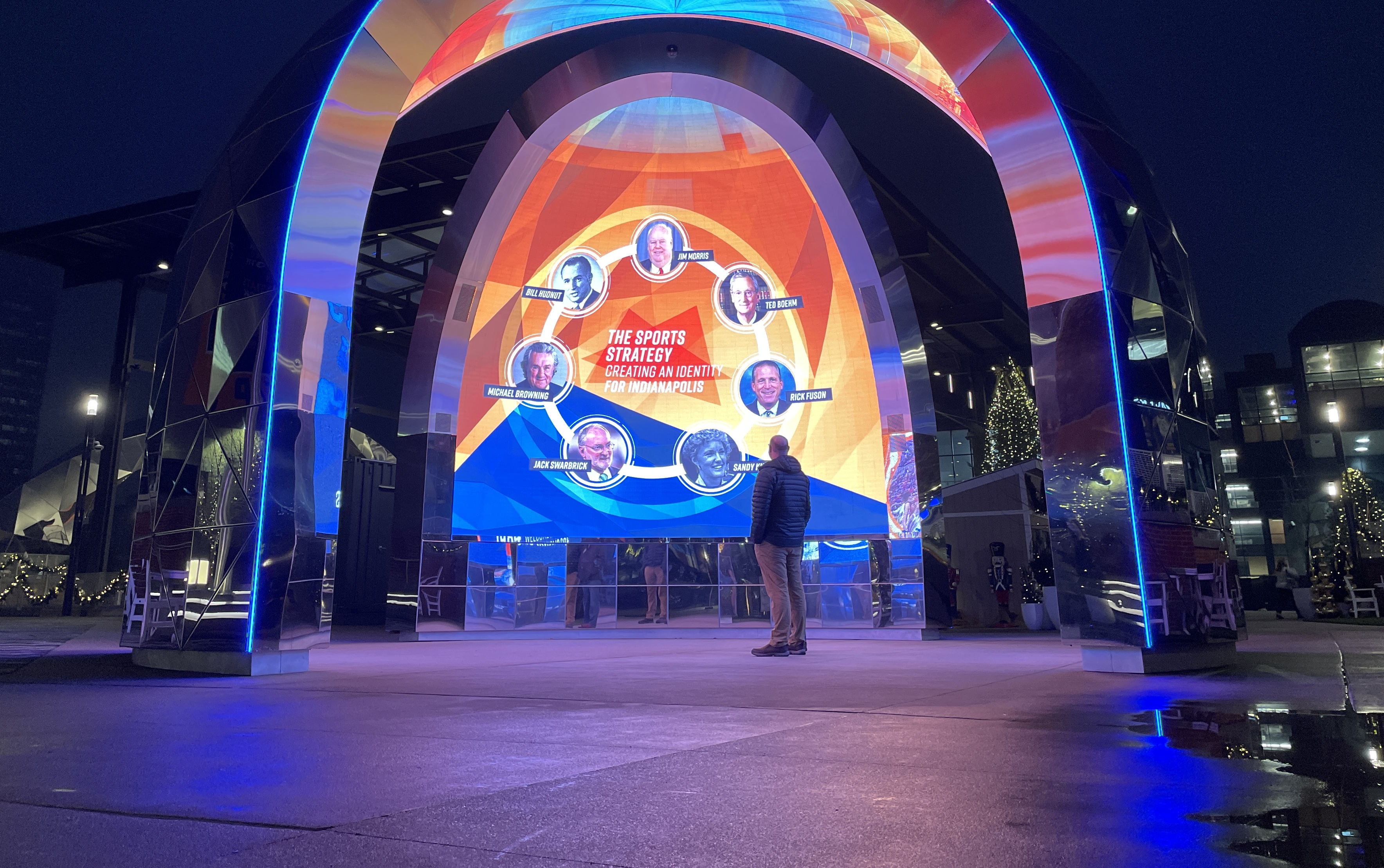 Visitor beneath the illuminated media sculpture at Bicentennial Unity Plaza, Indianapolis