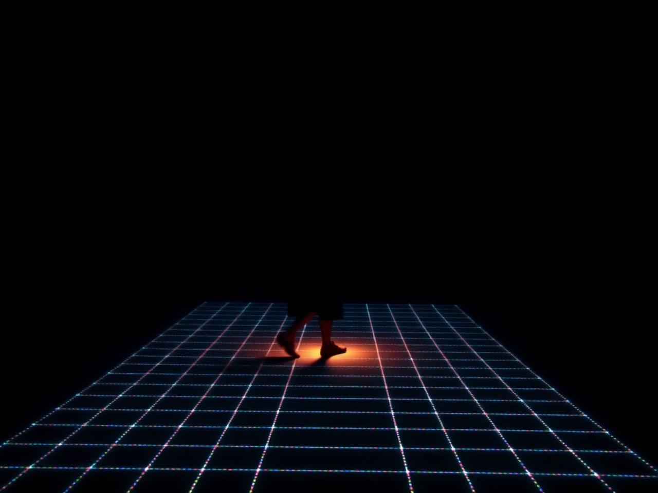 A visitor moving across a sensor-lit installation floor