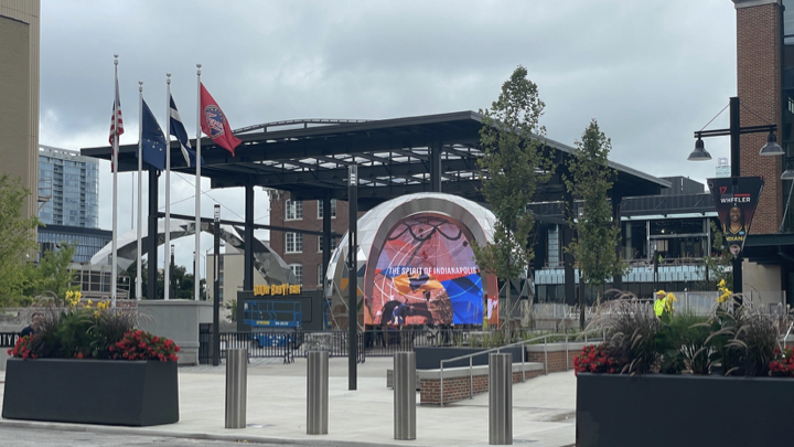 Sculptural digital arch seen within an outdoor entertainment district