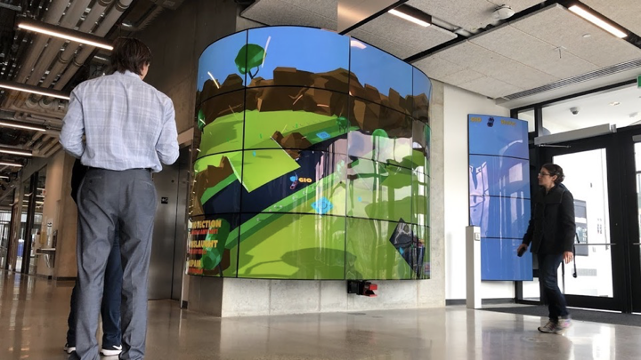 Visitors engaging with a curved multi-screen interactive installation